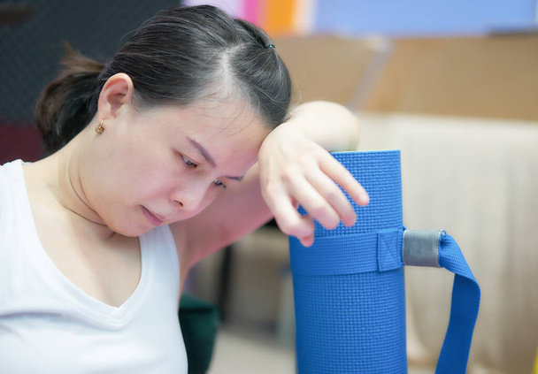 ázsiai nő put head on yoga mat fáradt edzés után - Fotó, kép