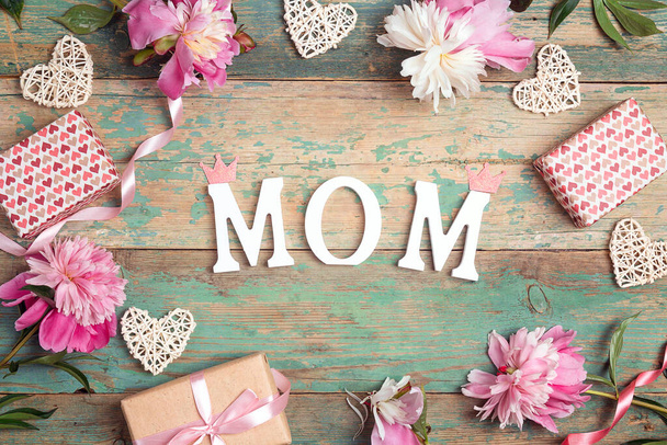 Mothers day background with pink peonies, gifts and hearts on an old turquoise boards with shabby paint. Place for text, top down composition. - Foto, Bild