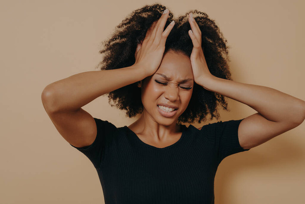 Schockiertes afroamerikanisches gestresstes Mädchen hält Hände auf dem Kopf und zeigt Verzweiflung - Foto, Bild