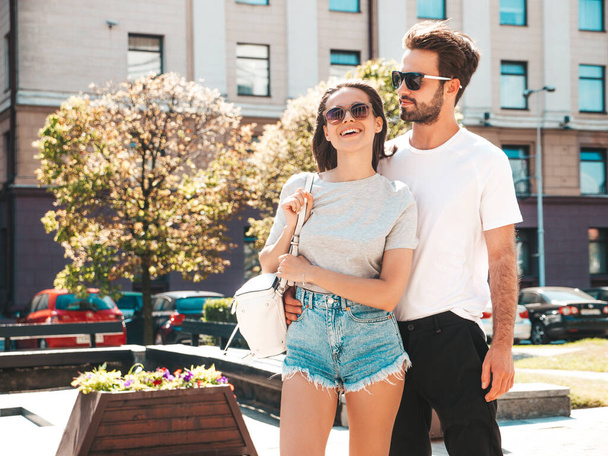 Portrait of smiling beautiful woman and her handsome boyfriend. Woman in casual summer clothes. Happy cheerful family. Female having fun. Couple posing on the street background in sunglasses - Photo, Image