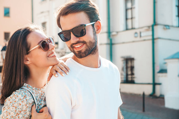 Portrait of smiling beautiful woman and her handsome boyfriend. Woman in casual summer clothes. Happy cheerful family. Female having fun. Couple posing on the street background in sunglasses - Фото, зображення