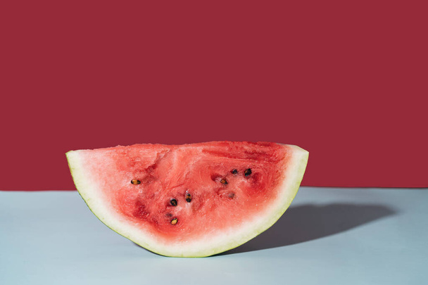 Piece of ripe watermelon against red background. - Foto, Imagen