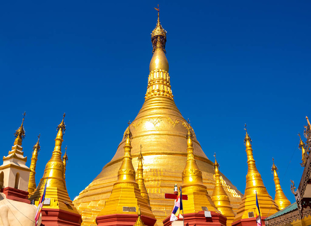 A group of golden pagodas under the blue sky of Myanmar - Photo, Image
