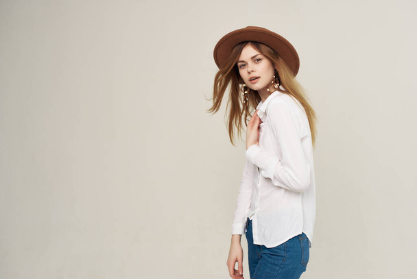 женщина в белой рубашке в шляпе в современном стиле создает гламурный изолированный фон - Фото, изображение