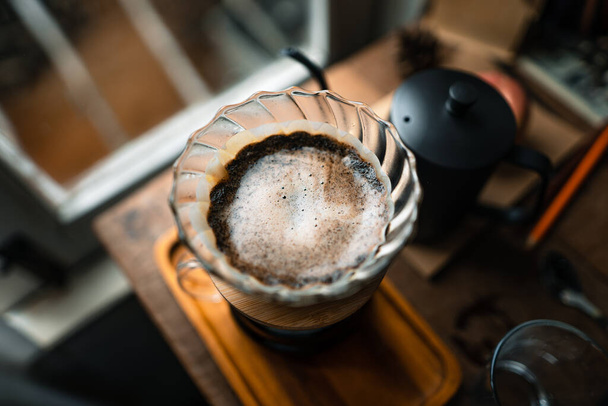 hot water into coffee dripper above glass jar. - Photo, Image