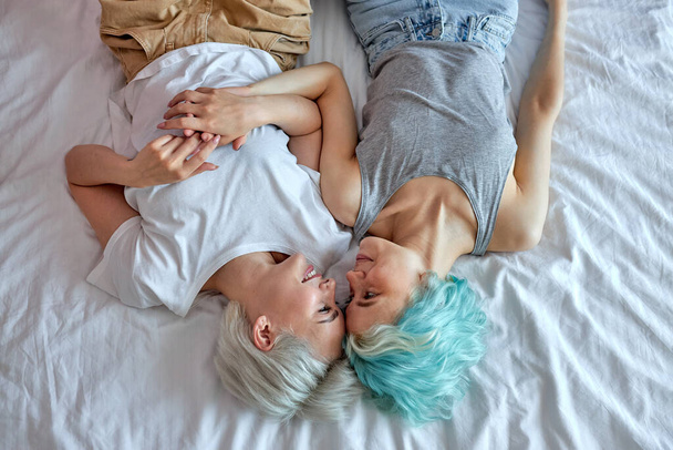Lesbian couple in the morning, happy wake-up, hugging and kissing, top view portrait - Foto, Bild