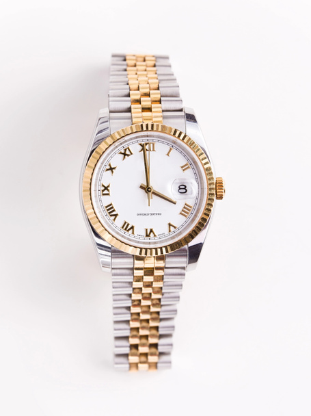 Ακριβό χρυσό λοξό ρολόι με λευκό πρόσωπο και χρυσά χέρια και αριθμούς σε λευκό φόντο - Φωτογραφία, εικόνα