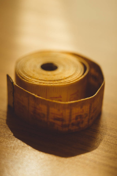 Old yellow measuring tape on the table. - 写真・画像