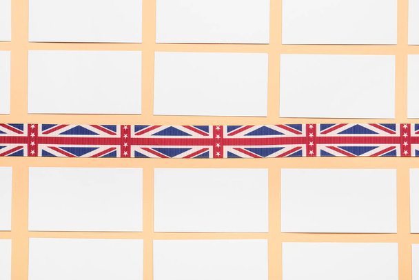 Бланшируйте визитки и полоску цветов британского флага на столе. Концепция изучения английского языка - Фото, изображение