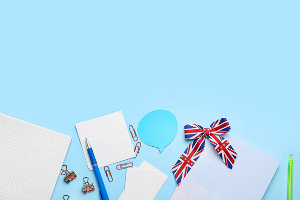 Briefpapier und Schleife in den Farben der britischen Flagge auf blauem Hintergrund. Konzept des Englischlernens - Foto, Bild