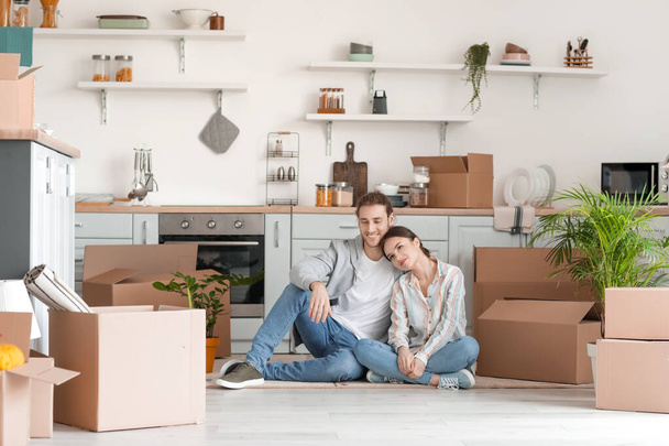 Jeune couple avec des boîtes en carton dans leur nouvelle maison le jour du déménagement - Photo, image