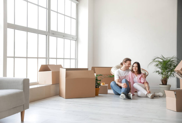 Young couple with cardboard boxes in their new house on moving day - Φωτογραφία, εικόνα