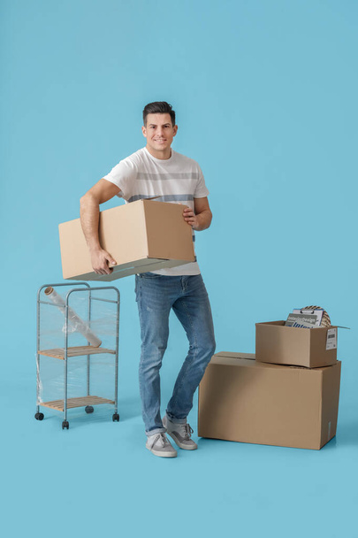 Jóképű férfi mozgó dobozok színes háttér - Fotó, kép