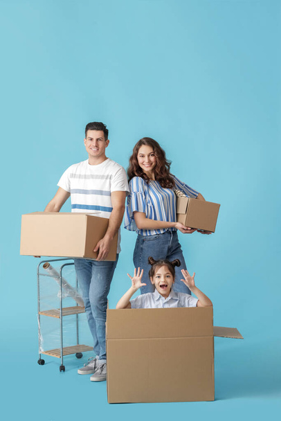 Famiglia felice con scatole in movimento su sfondo di colore - Foto, immagini