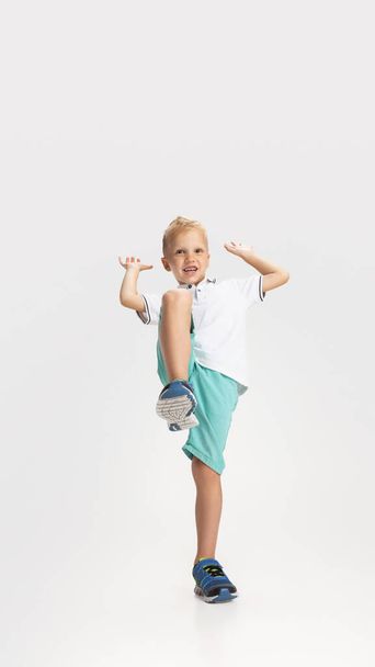 Portrait of cute preschool boy in shirt and shorts isolated on white studio background. Copyspace for ad. Childhood, education, emotion concept - Foto, Imagen
