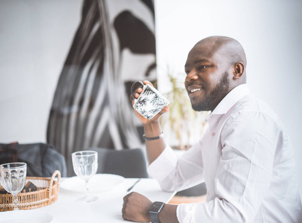 Successful Young Businessman. African American Man Smiling While Sitting At Breakfast In Luxury Apartment. Concept Of Rich Life, Personal Growth - Photo, Image
