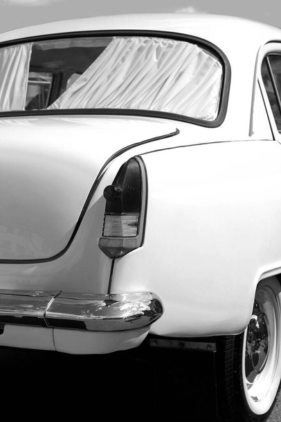 achterkant van de auto van de jaren 50 met een achterlicht en een chromen bumper - Foto, afbeelding