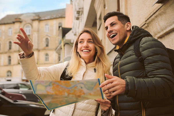 Couple of tourists with map on city street - Foto, Bild