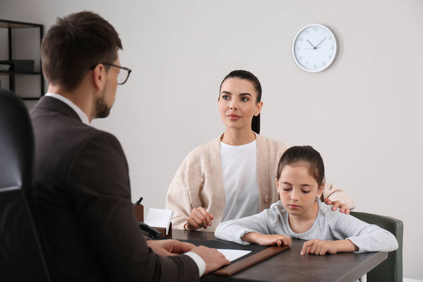 Mother and daughter having meeting with principal at school - Фото, изображение