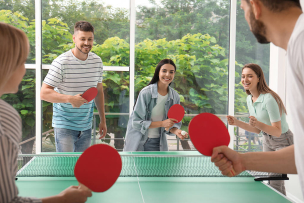 Happy friends playing ping pong together indoors - Foto, Bild