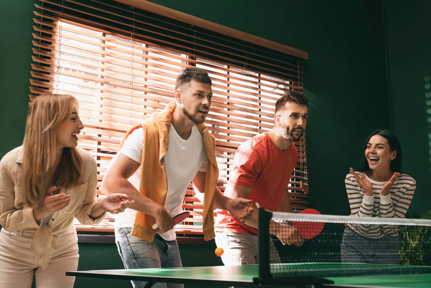 Happy friends playing ping pong together indoors - Foto, immagini