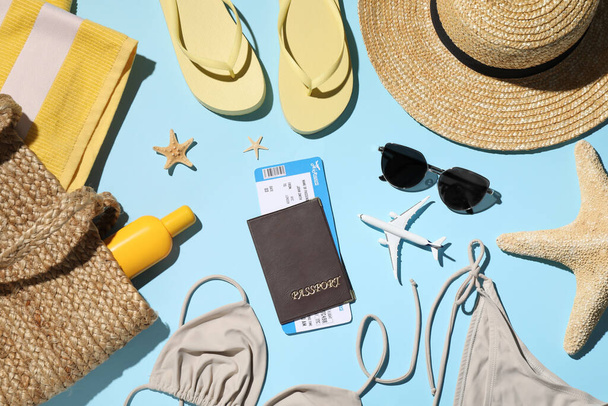 Flat lay composition with passport, tickets and beach accessories on light blue background. Time to travel - Foto, afbeelding