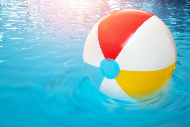 Inflatable beach ball floating in swimming pool  - Zdjęcie, obraz
