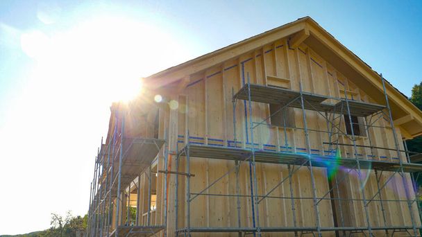 CLOSE UP: Bright sunbeams shine on a wooden house being built in countryside. - Photo, Image