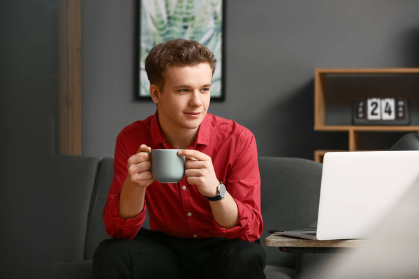 Giovane uomo che beve caffè in ufficio - Foto, immagini
