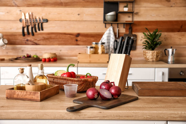 Soporte con juego de cuchillos y verduras en la mesa en la cocina - Foto, Imagen