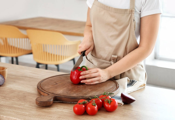 Frau schneidet Paprika in Küche - Foto, Bild