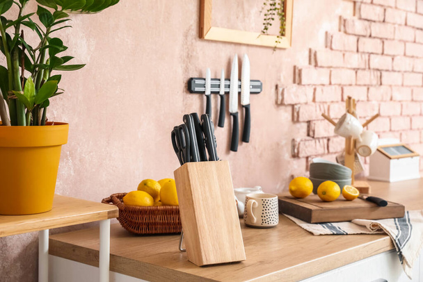 Soporte con cuchillos y limones en mostrador en cocina - Foto, imagen