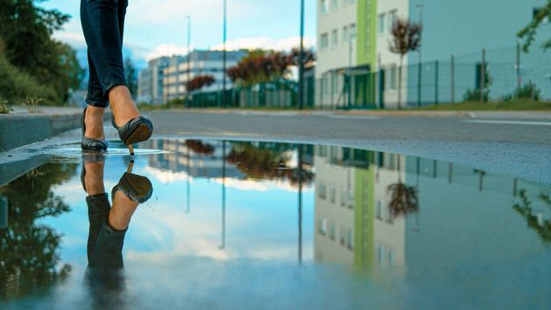 CLOSE UP Businesswoman in heels steps into a puddle on the side of an empty road - Photo, Image