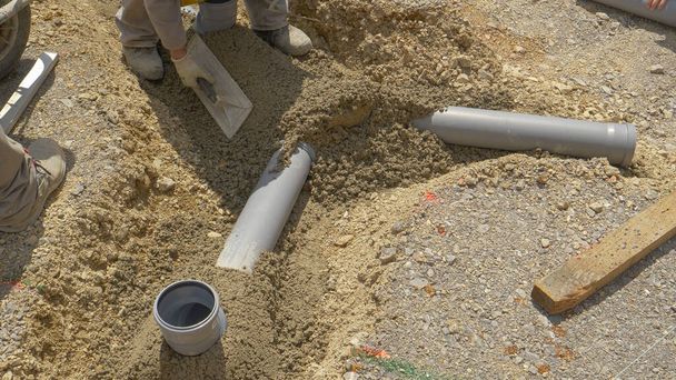 CLOSE UP: Group of unrecognizable contractors assemble a new sewage pipeline. - Photo, Image