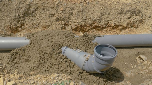 CLOSE UP: бетонное покрытие пластиковых канализационных труб высыхает на летнем солнце. - Фото, изображение