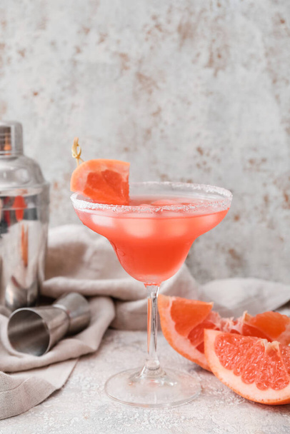 Glass of Hemingway daiquiri cocktail, grapefruit and shaker on grunge background - Foto, afbeelding