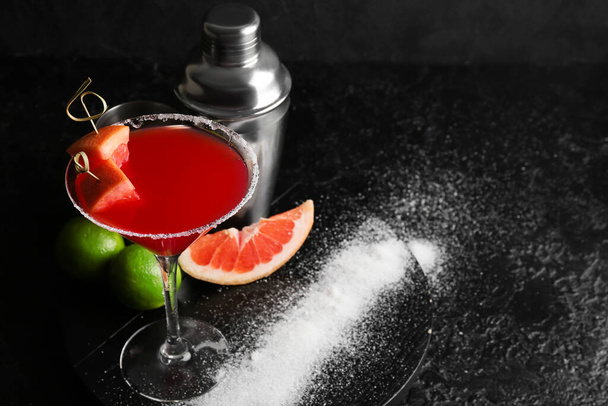 Glass of Hemingway daiquiri cocktail, shaker and citrus fruits on dark background - Photo, Image