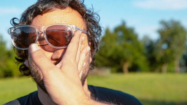 CLOSE UP: Чоловічі сонцезахисні окуляри вилітають з обличчя після того, як невідомий врізається в обличчя
. - Фото, зображення