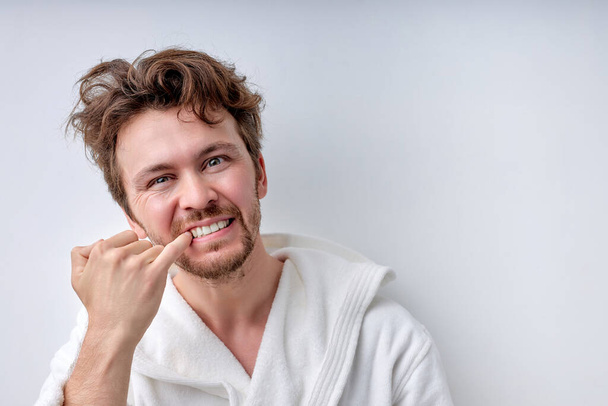 bearded young adult man looking at camera checking is mouth and teeth - Fotoğraf, Görsel