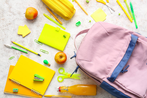School backpack and stationery on light background - Фото, изображение