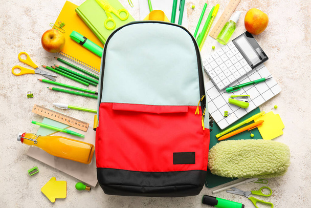 Schulrucksack und Schreibwaren auf hellem Hintergrund - Foto, Bild