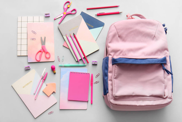 Schulrucksack und Schreibwaren auf hellem Hintergrund - Foto, Bild