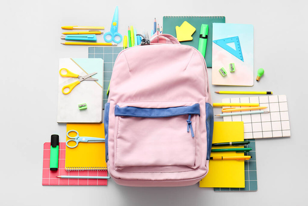 Schoolrugzak en briefpapier op lichte achtergrond - Foto, afbeelding