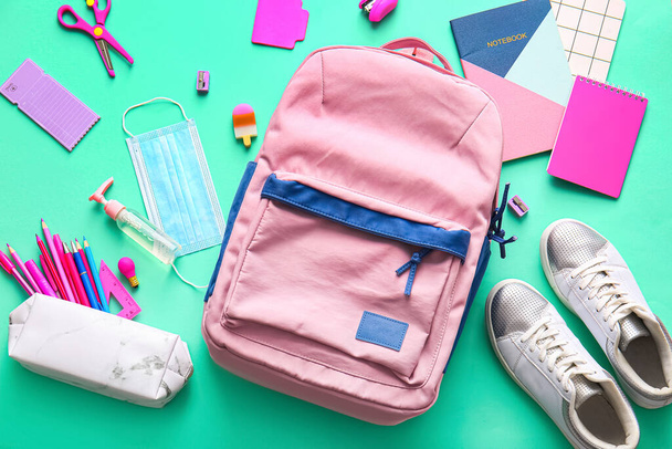 School backpack and stationery on color background - Φωτογραφία, εικόνα