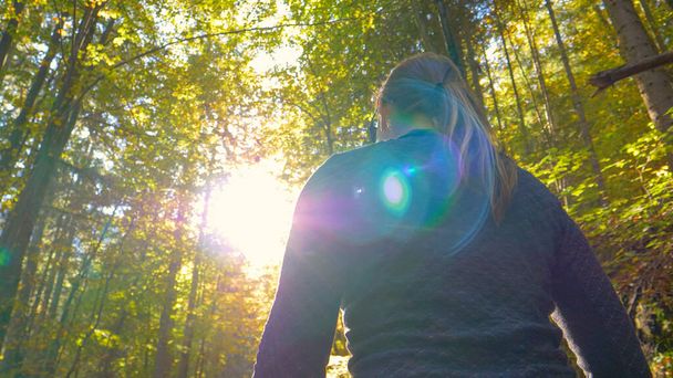 CLOSE UP: Mädchen genießt eine entspannte Wanderung durch einen ruhigen Wald in wechselnden Farben. - Foto, Bild