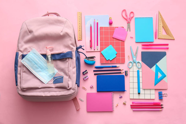 School backpack and stationery on color background - 写真・画像
