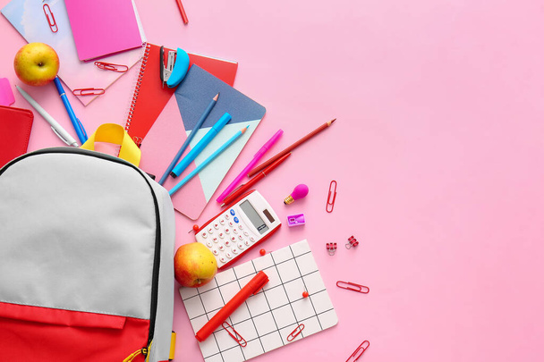 Schulrucksack und Schreibwaren auf farbigem Hintergrund - Foto, Bild