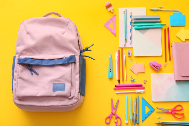 School rugzak en briefpapier op kleur achtergrond - Foto, afbeelding