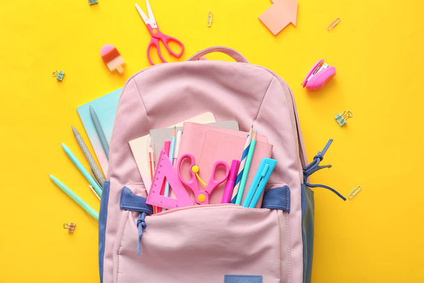 School backpack and stationery on color background - Фото, зображення
