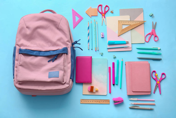 Mochila escolar y papelería sobre fondo de color - Foto, Imagen